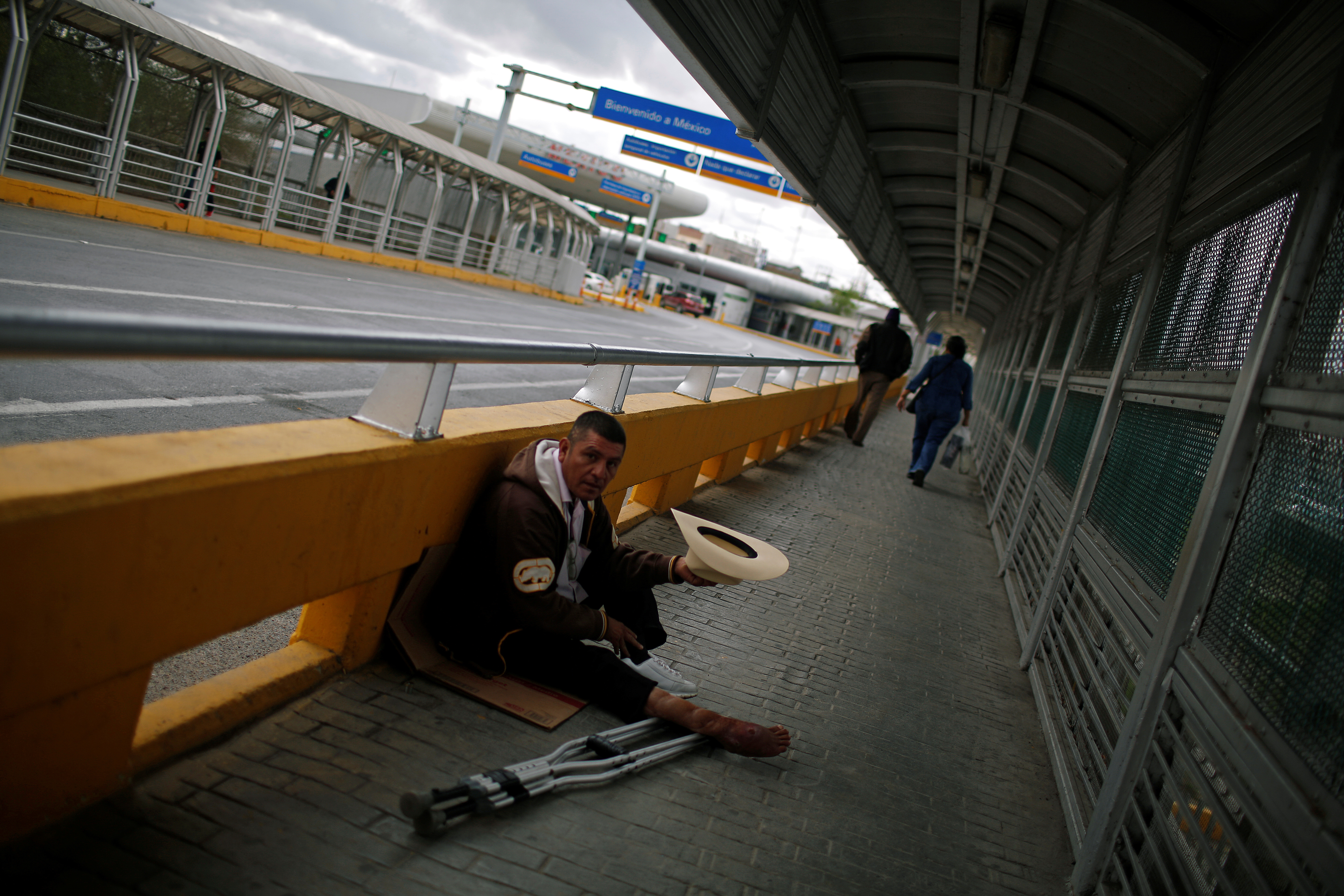 A beggar sits at the McAllen-Hidalgo international bridge in Reynosa