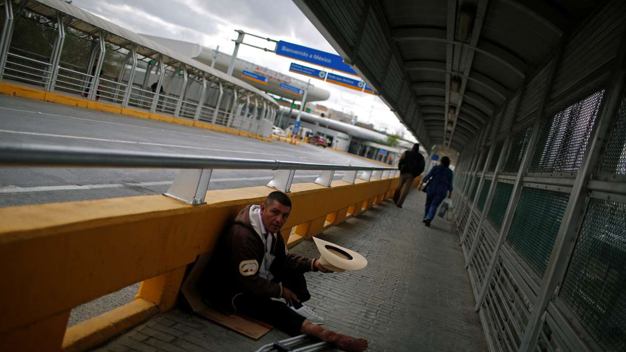 A beggar sits at the McAllen-Hidalgo international bridge in Reynosa