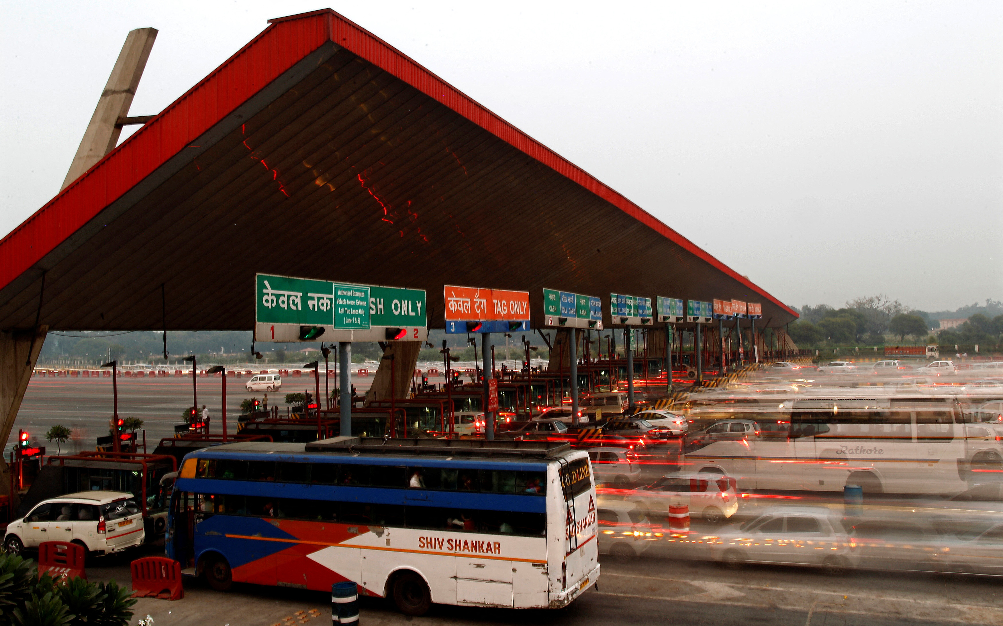 FILE PHOTO: Vehicles pass through a toll plaza in Gurgaon on the outskirts of New Delhi