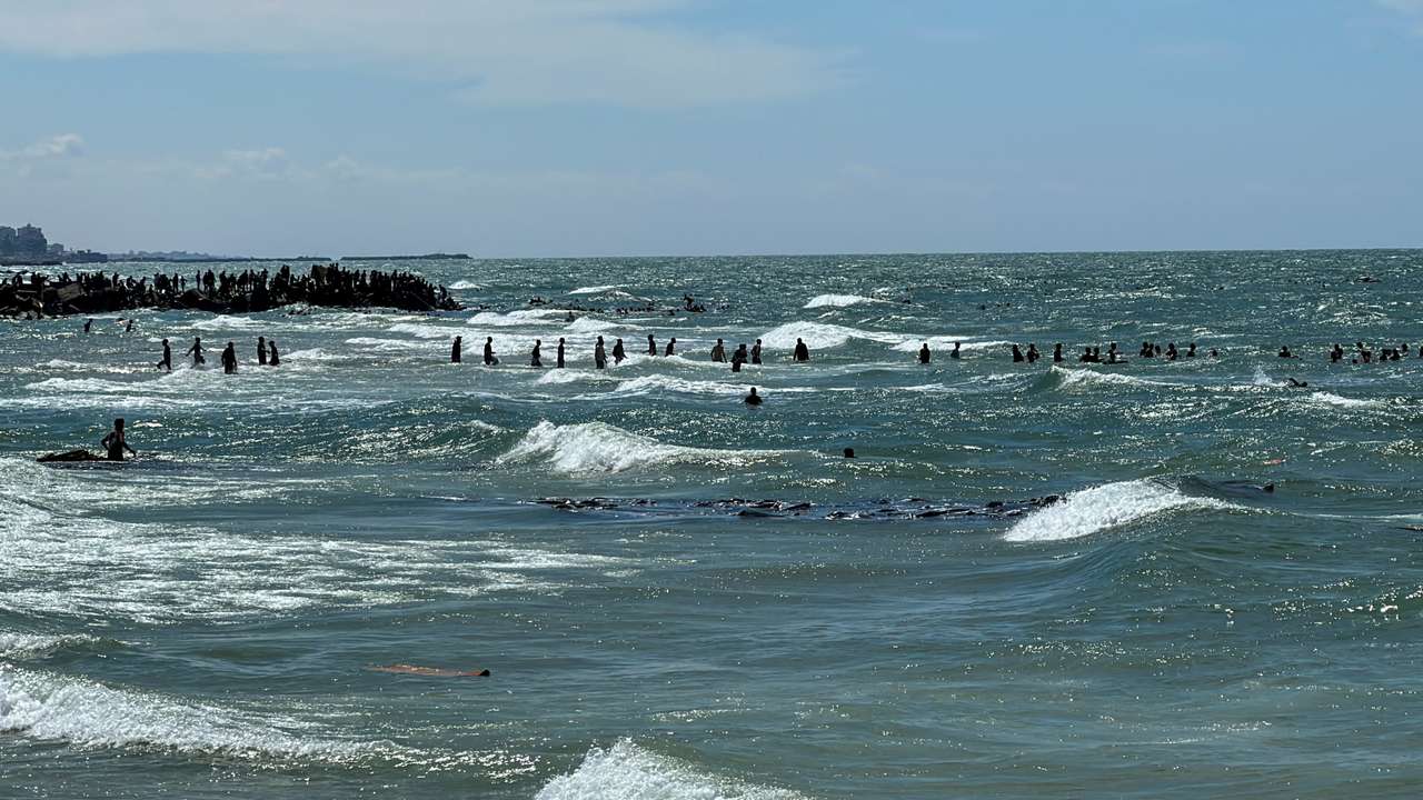 Palestinians gather at the sea to collect aid airdropped by an airplane, amid the ongoing conflict between Israel and Hamas, in the northern Gaza Strip