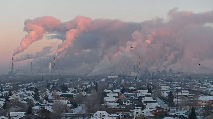 Steam rises from chimneys of the Gazprom Neft's oil refinery in Omsk