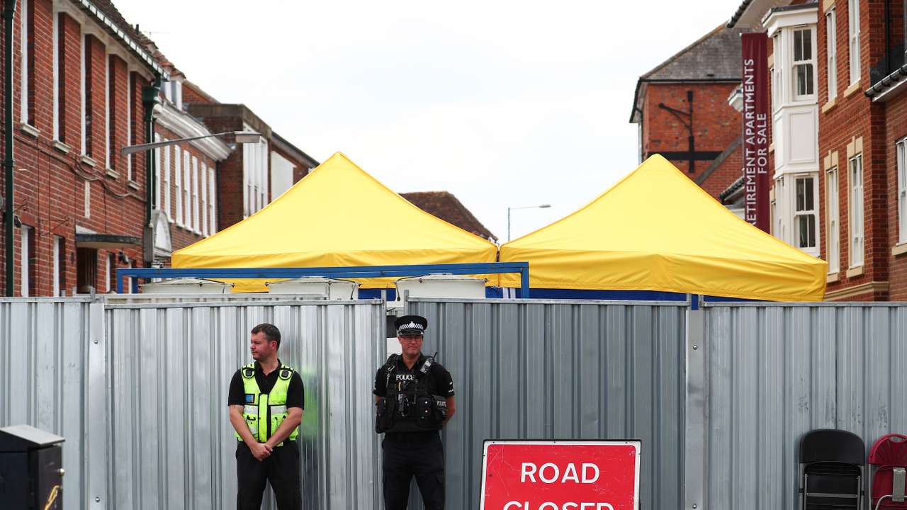 Police officers stand outside the street where Dawn Sturgess lived before dying after being exposed to a Novichok nerve agent, in Salisbury