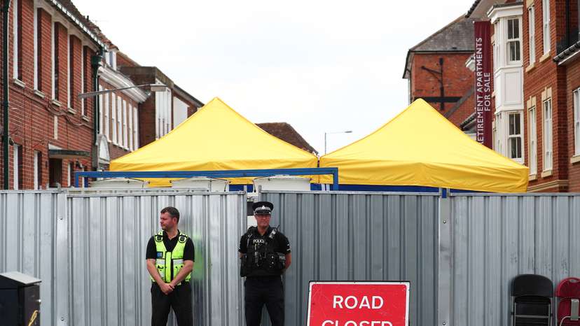 Police officers stand outside the street where Dawn Sturgess lived before dying after being exposed to a Novichok nerve agent, in Salisbury