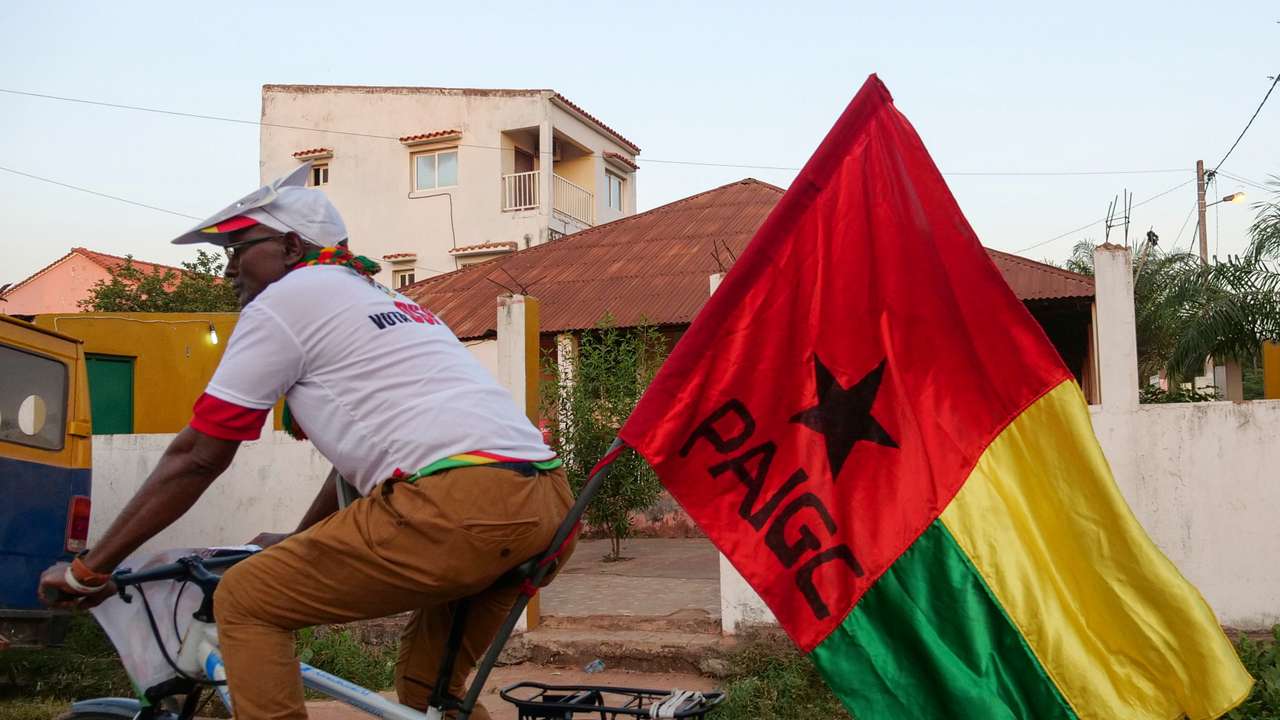 A supporter of presidential candidate Domingos Simoes Pereira rides a bicycle in Bissau