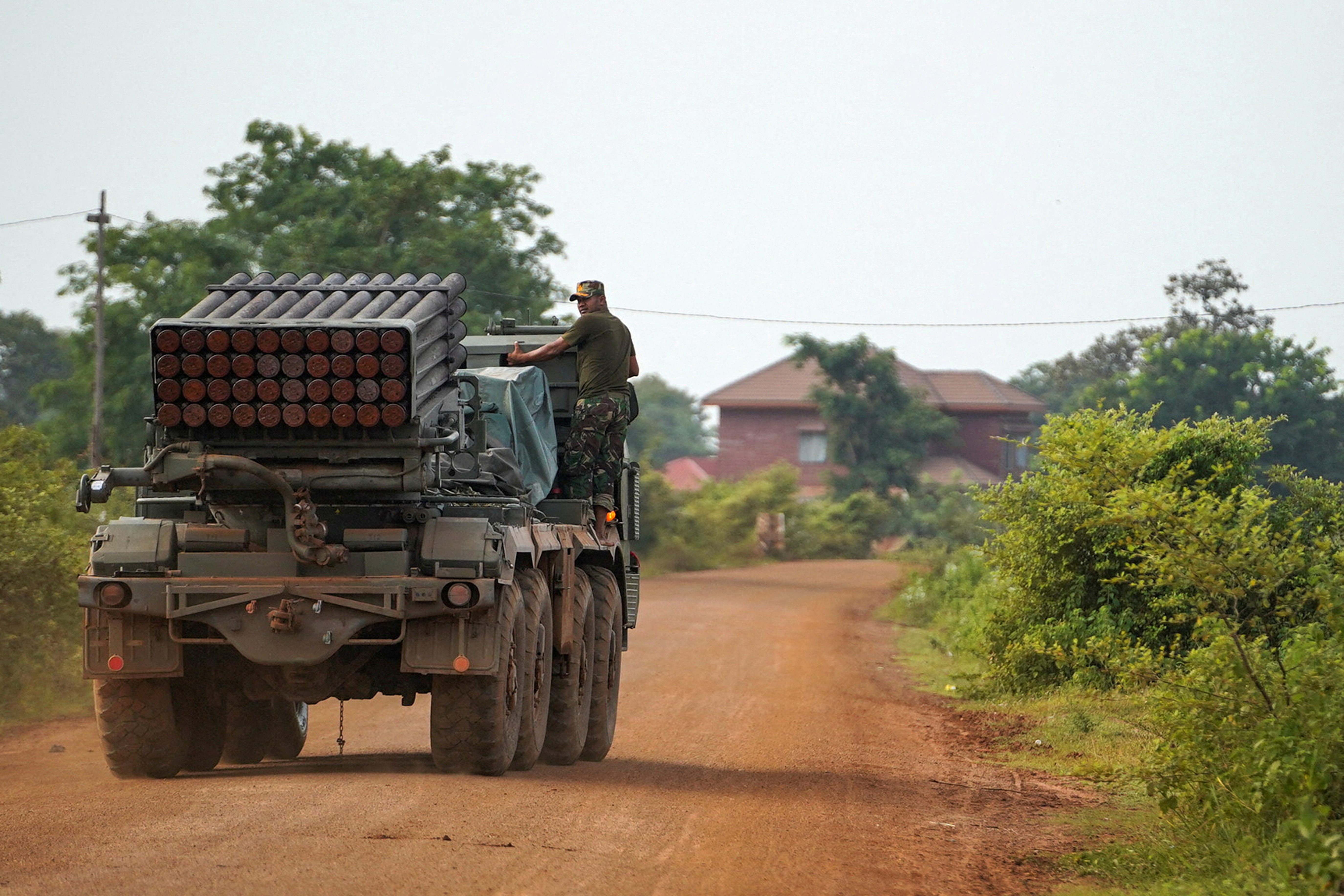 A Cambodian military personnel stands on a BM-21 Grad multiple rocket launcher in Oddar Meanchey province