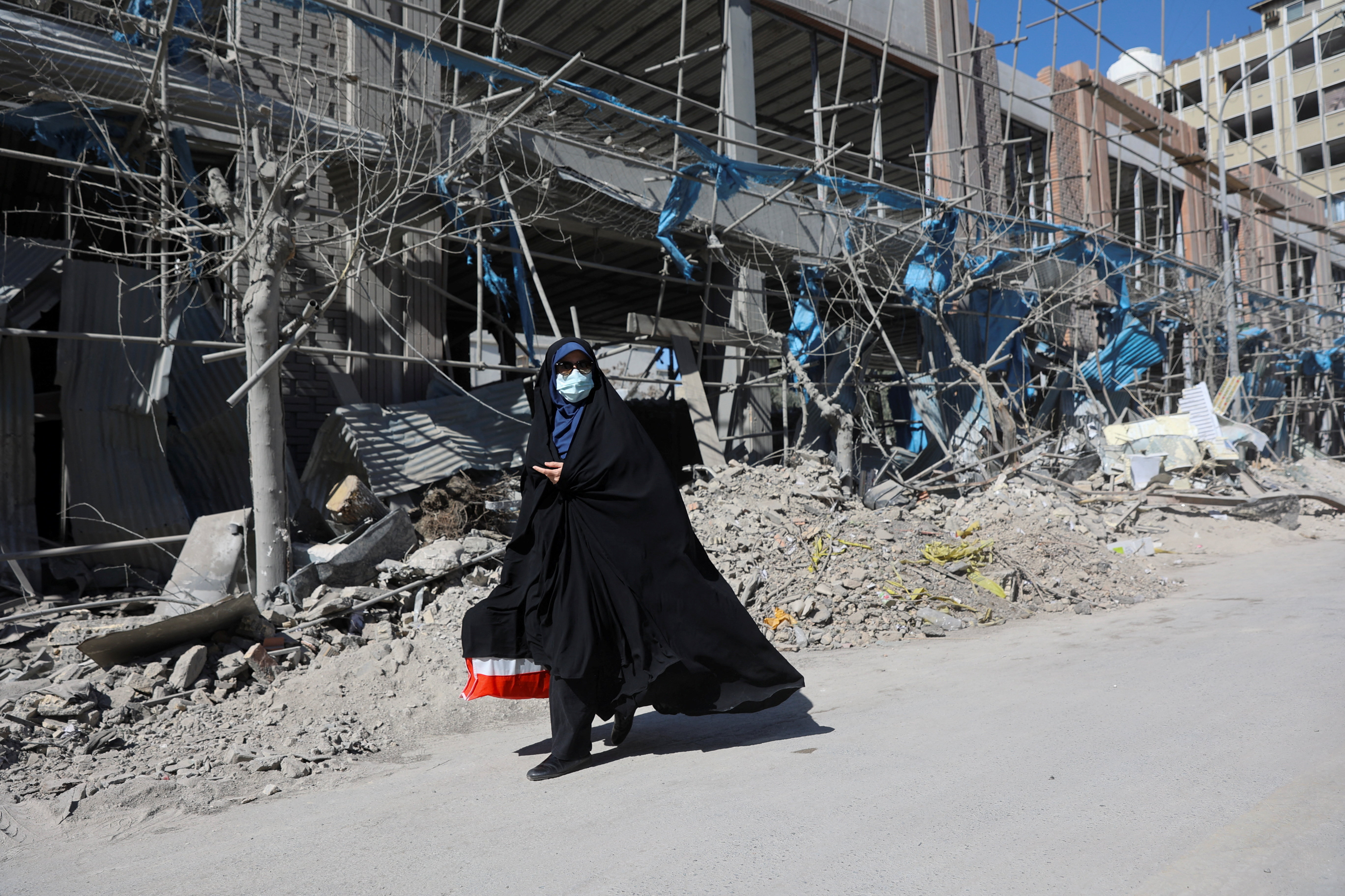 A woman walks on the street amid the U.S.-Israeli conflict with Iran, in Tehran