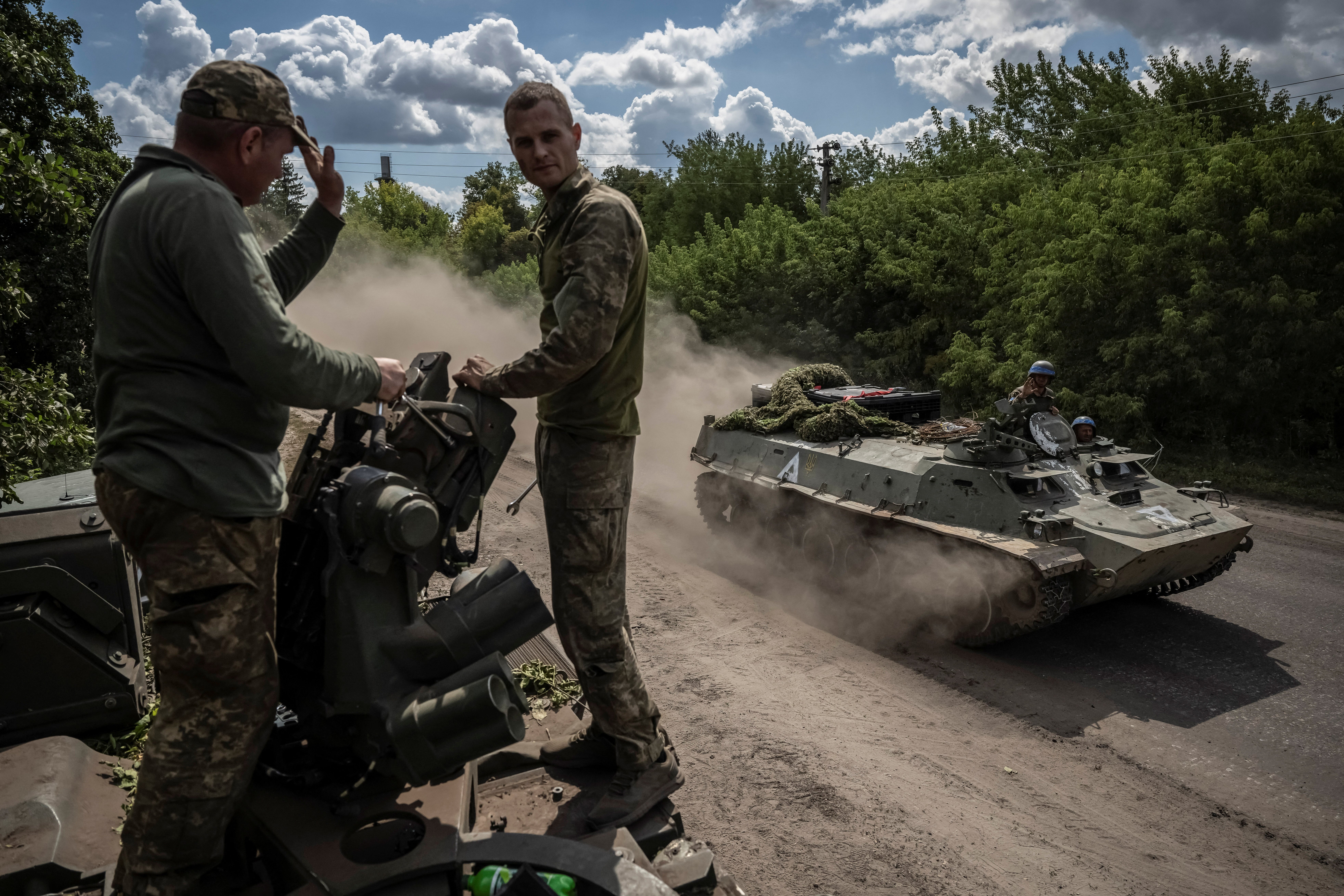 Ukrainian service members ride an Armoured Personnel Carrier near the Russian border in Sumy region