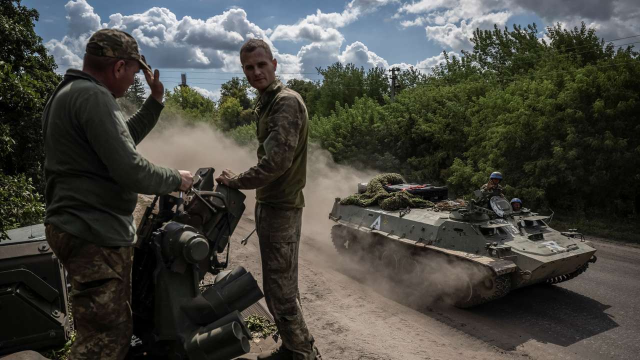 Ukrainian service members ride an Armoured Personnel Carrier near the Russian border in Sumy region