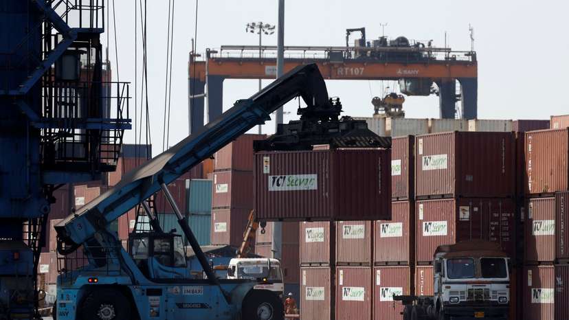 A mobile crane carries a container at Deendayal Port in Kandla