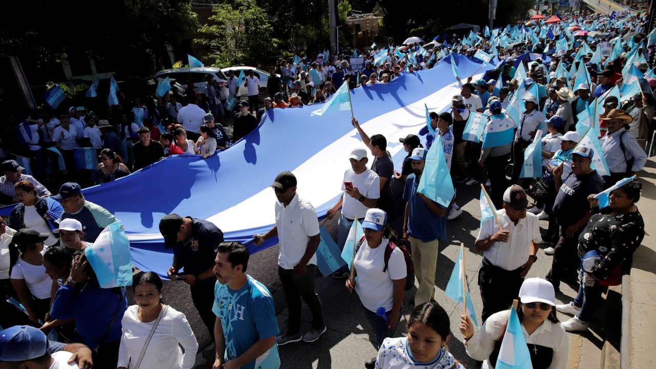 Supporters of Honduras' right-wing National Party candidate Asry Asfura hold a Honduran flag as he campaigns ahead of the November 30 presidential election in Tegucigalpa, Honduras, November 8, 2025. REUTERS/Leonel Estrada