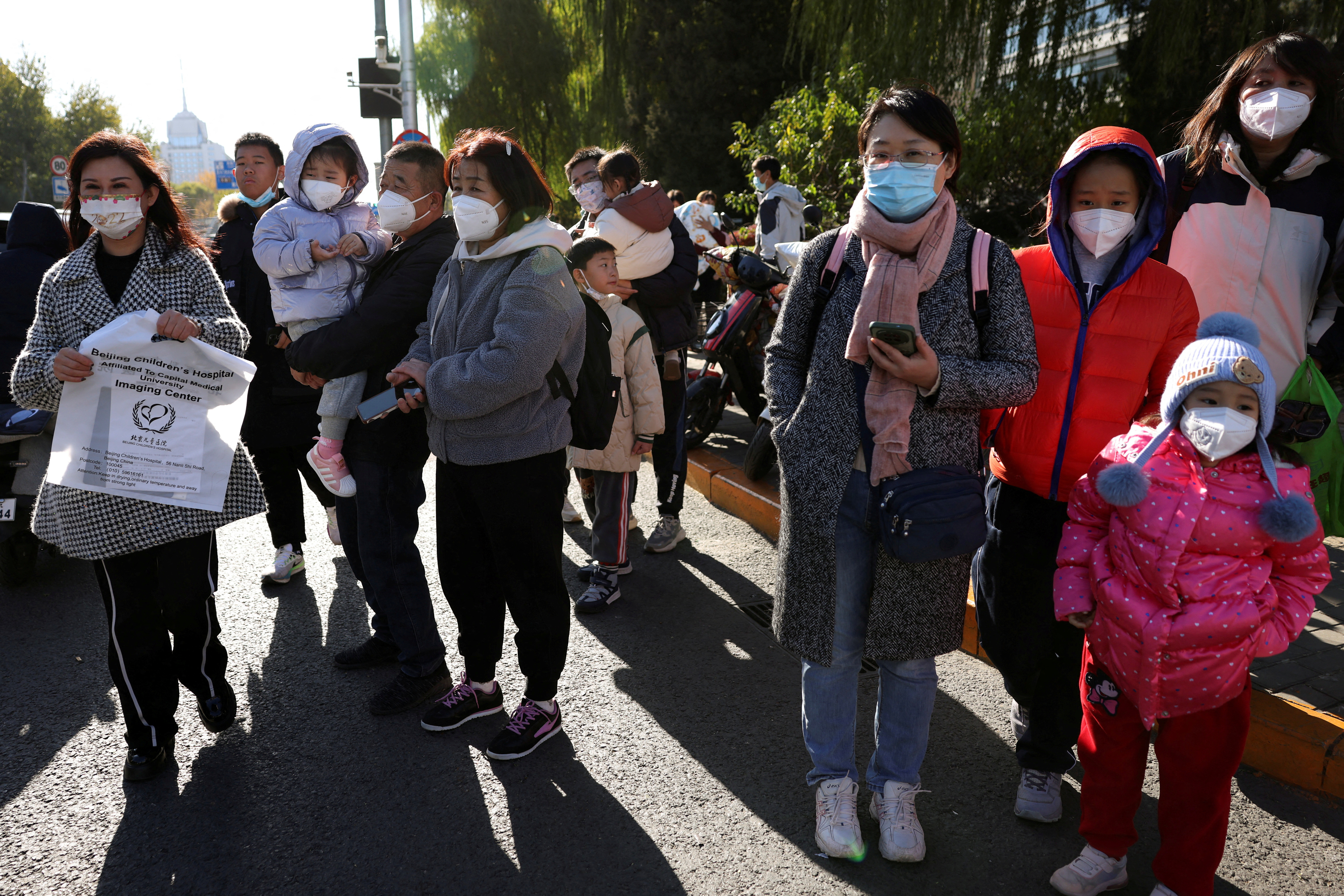 FILE PHOTO: People wait outside a children's hospital in Beijing