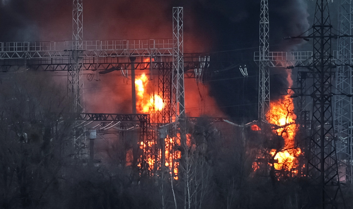 Smoke and fire are seen around high-voltage lines at a site of a Russian missile strike outside Kharkiv