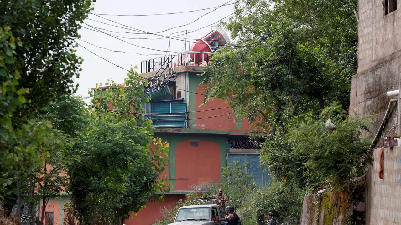 Security force personnel stand guard in front of Bilal Mosque after it was hit by an Indian strike in Muzaffarabad