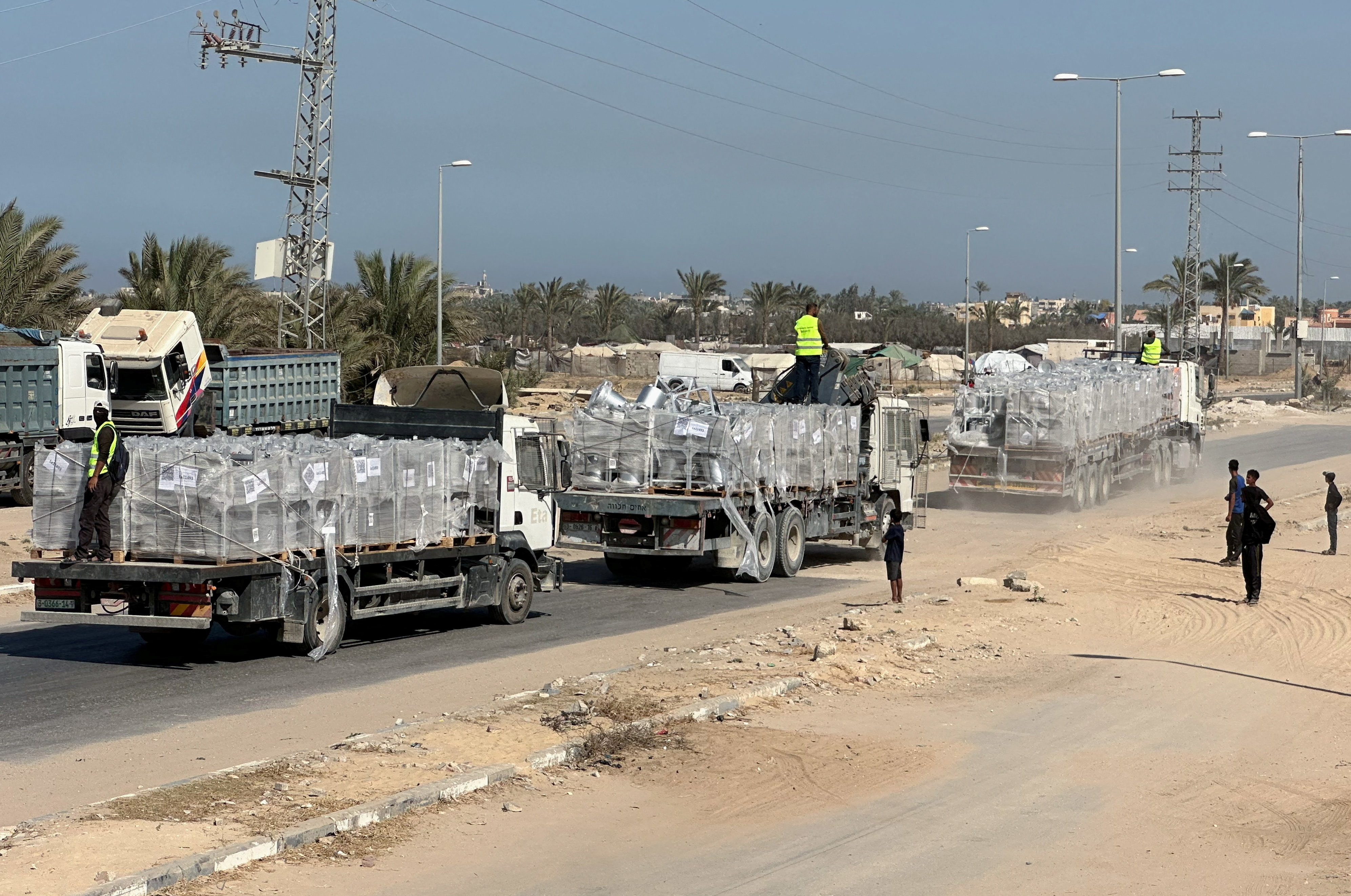 Trucks carry aid for Palestinians, amid a ceasefire between Israel and Hamas, in Deir Al-Balah