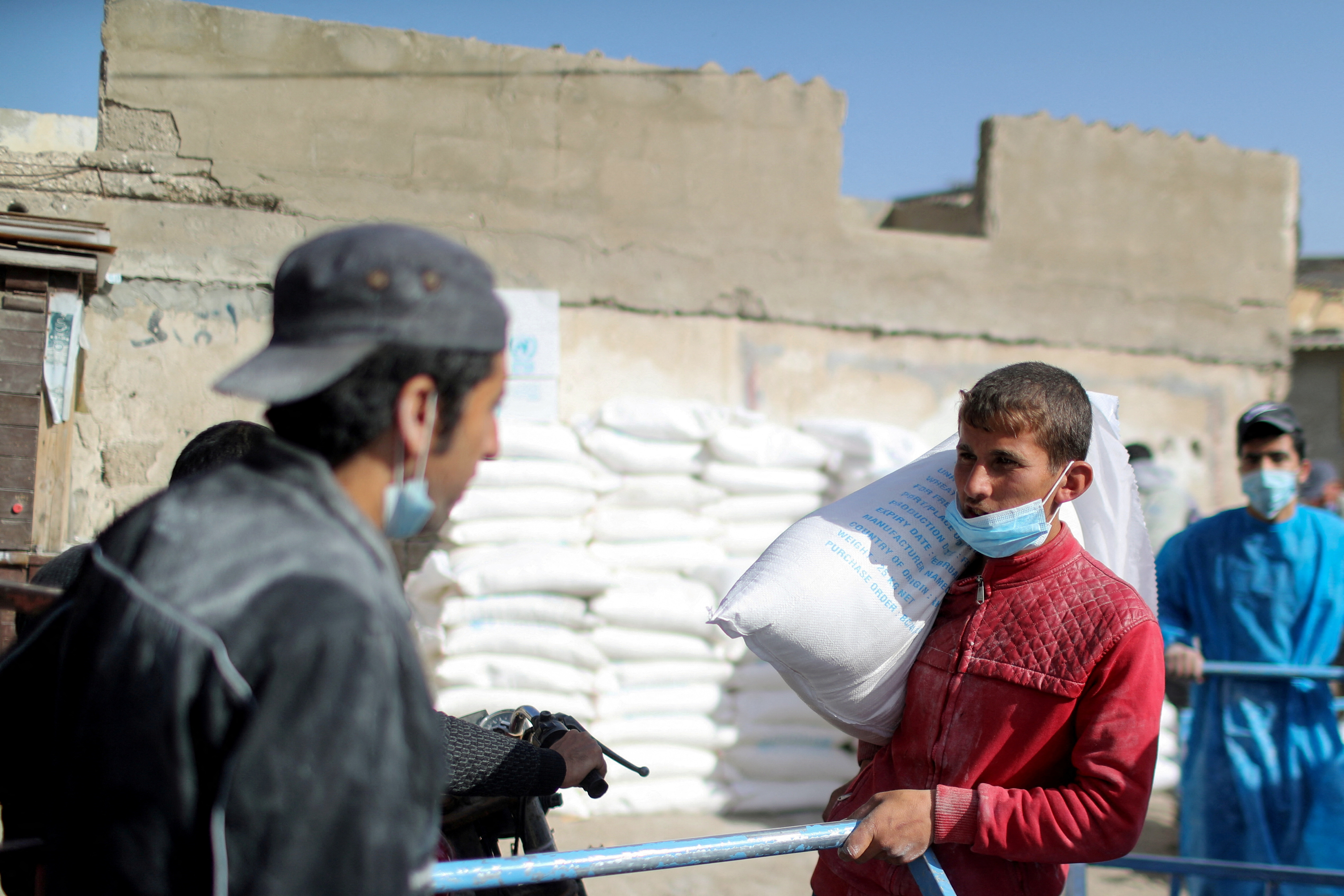 FILE PHOTO: Palestinians receive food supplies at UNRWA distribution center in Gaza