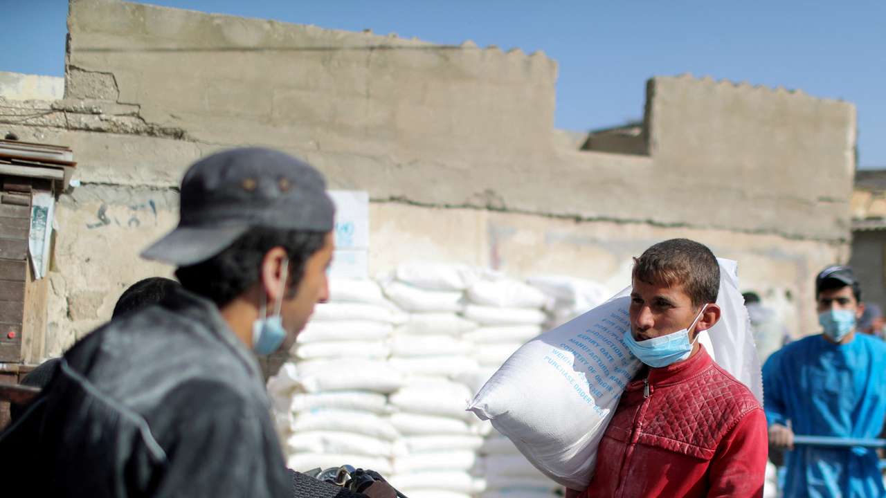 FILE PHOTO: Palestinians receive food supplies at UNRWA distribution center in Gaza