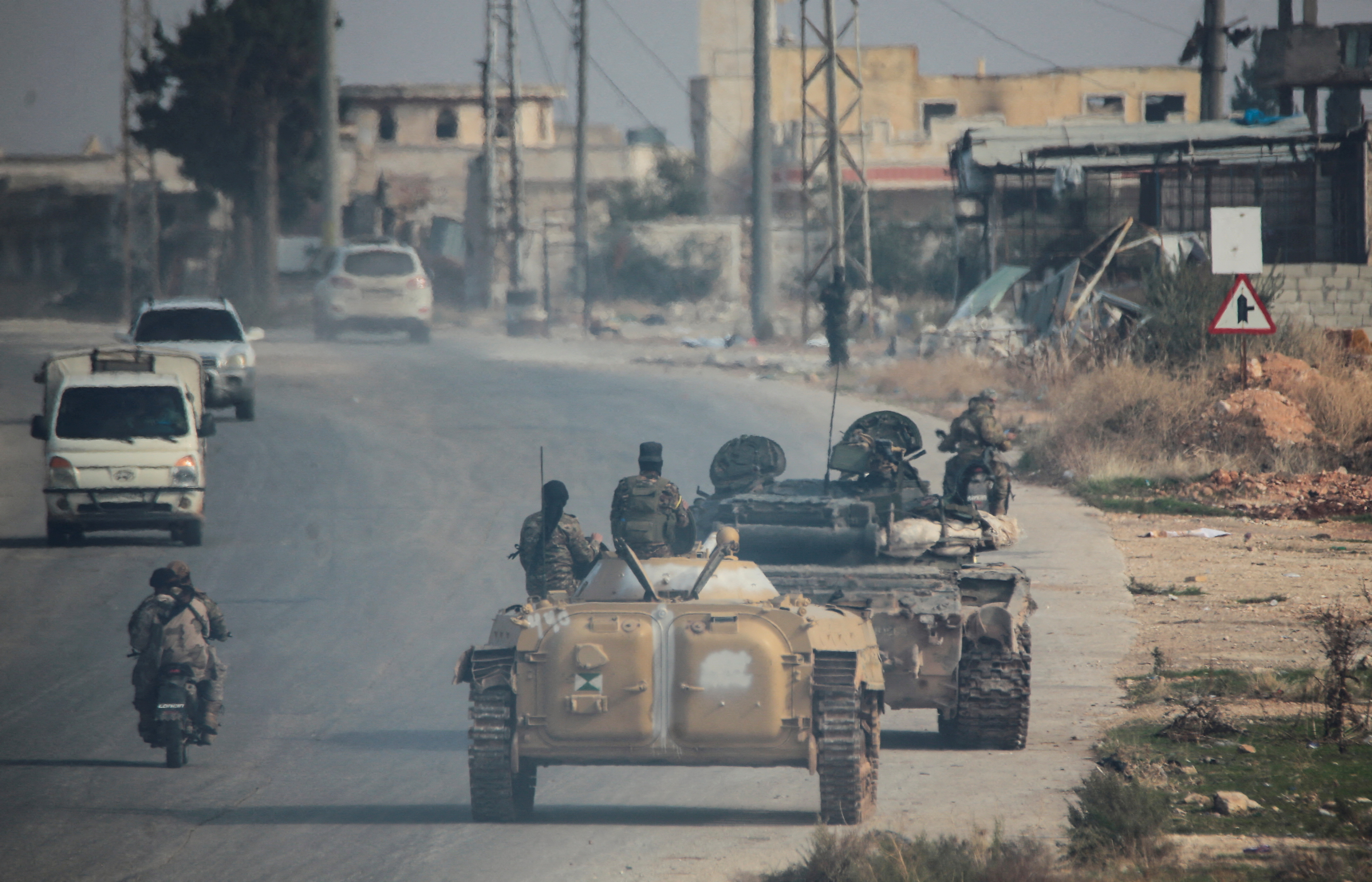 Rebels led by the Islamist militant group Hayat Tahrir al-Sham drive along a street in al-Rashideen, Aleppo province