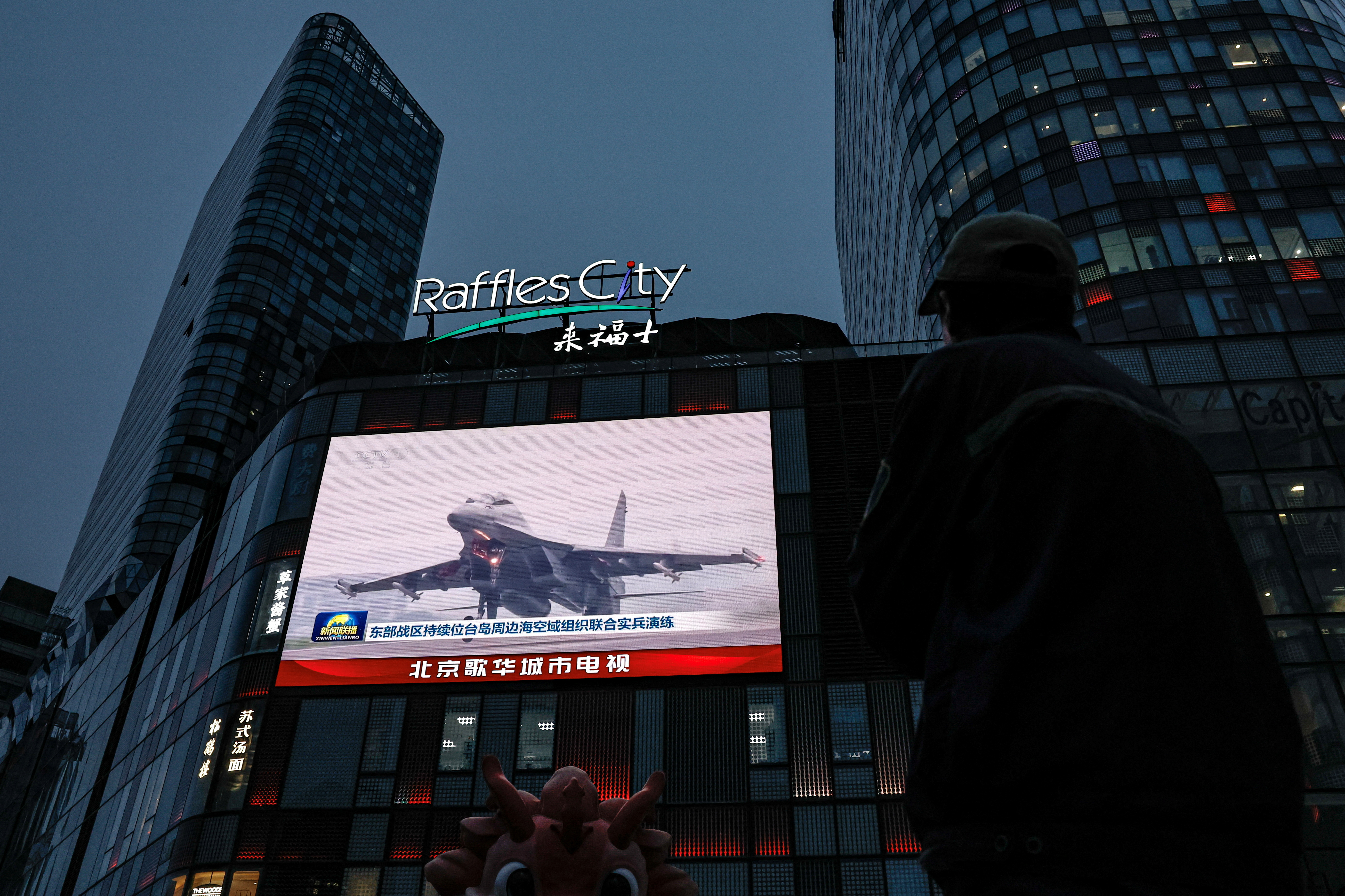 A screen shows news footage of military drills conducted in areas around the island of Taiwan  by the Eastern Theatre Command of the PLA in Beijing
