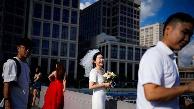 FILE PHOTO: Couples prepare to get their photo taken during a wedding photography shoot on a street, in Shanghai