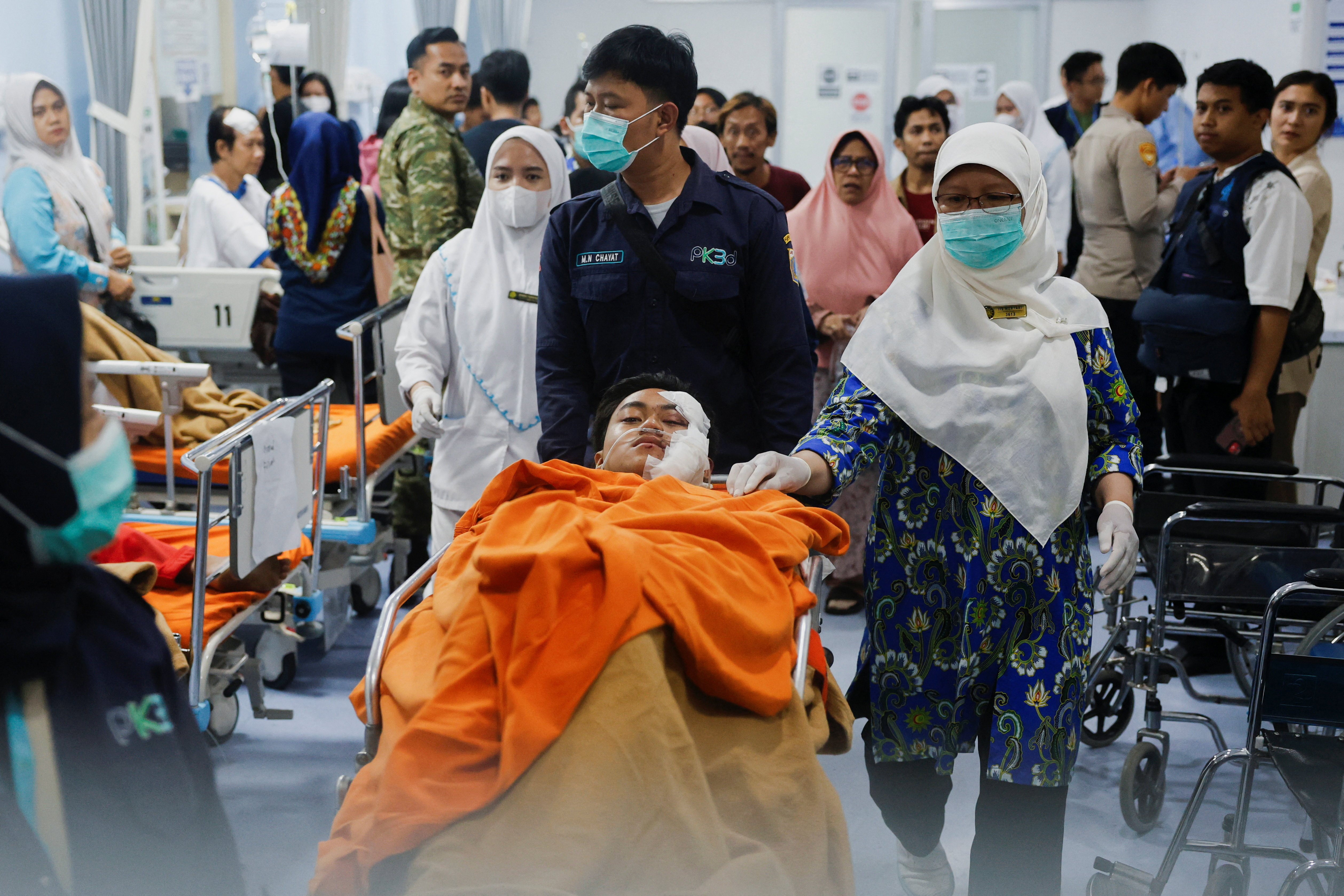 Medical workers push an injured student on the stretcher at Jakarta Islamic hospital after an explosion occurred during Friday prayers at a mosque inside a school complex in Jakarta