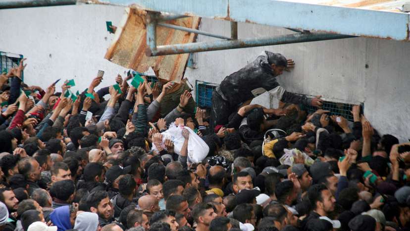 FILE PHOTO: Palestinians gather to receive aid outside an UNRWA warehouse in Gaza City