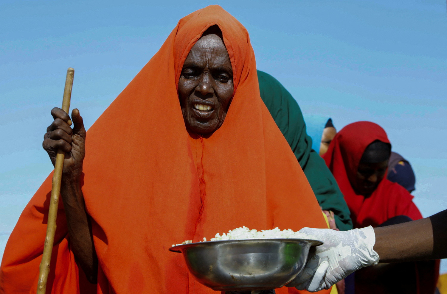 An internally displaced Somali woman receives iftar food rations for Ramadan, in the outskirt of Mogadishu