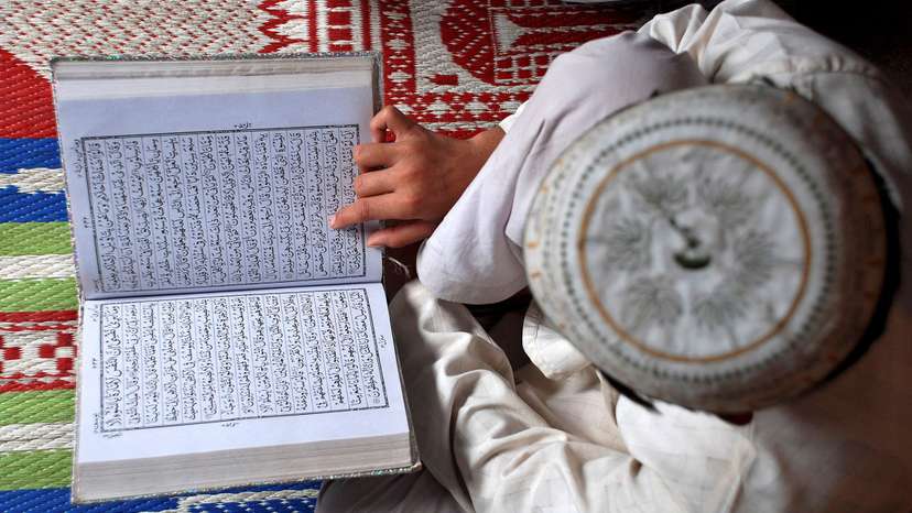 FILE PHOTO: A Muslim boy reads the Koran at a madrasa in Mathura, India