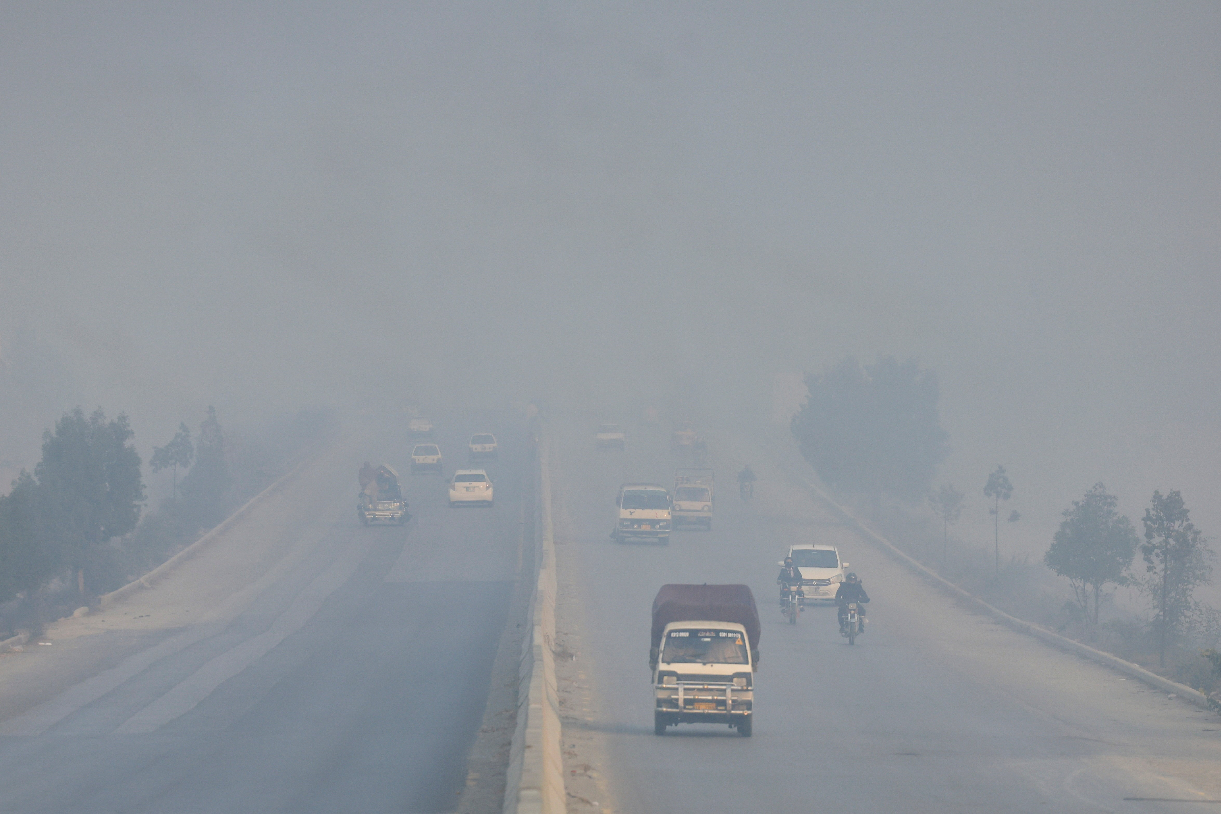 Vehicles move amid smog and air pollution during morning hours, in Peshawar
