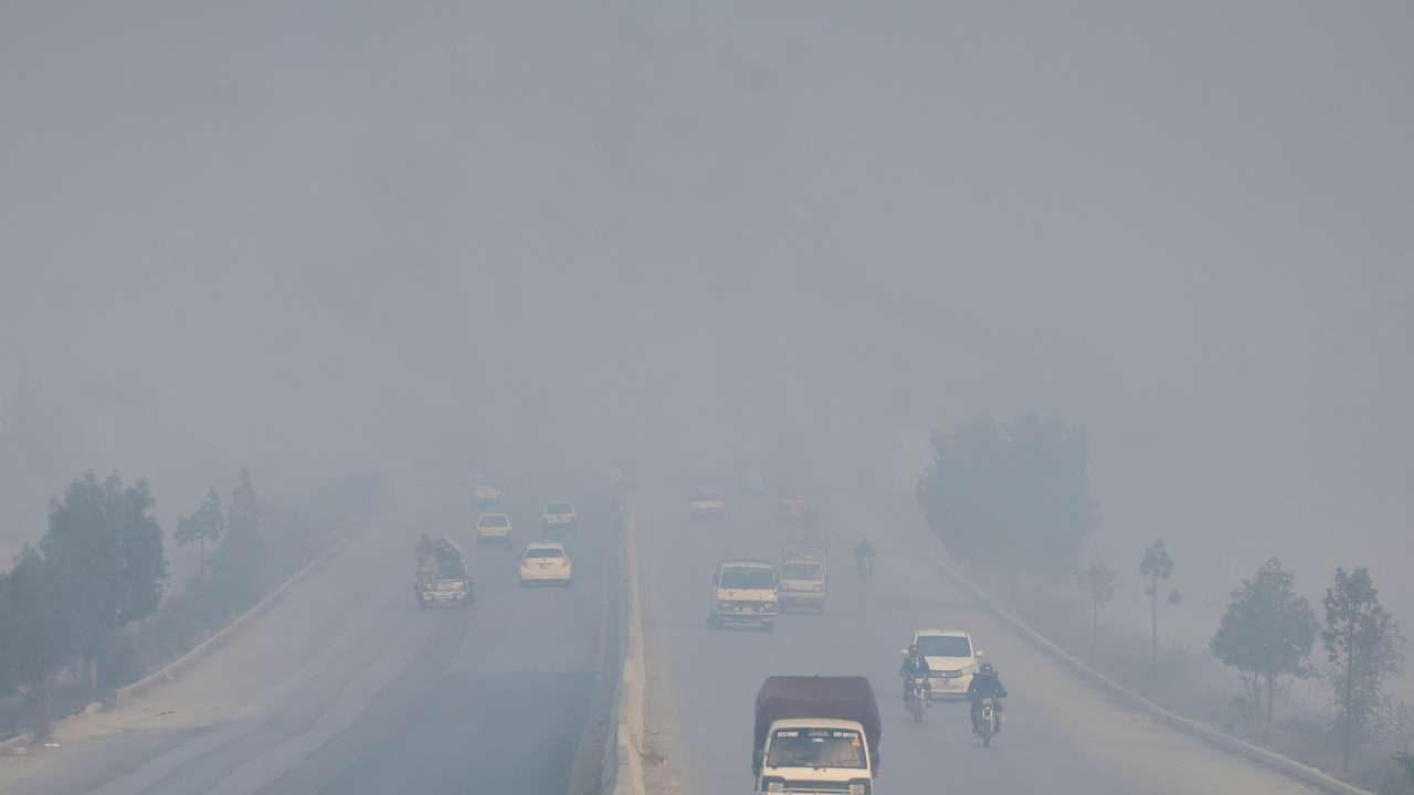 Vehicles move amid smog and air pollution during morning hours, in Peshawar
