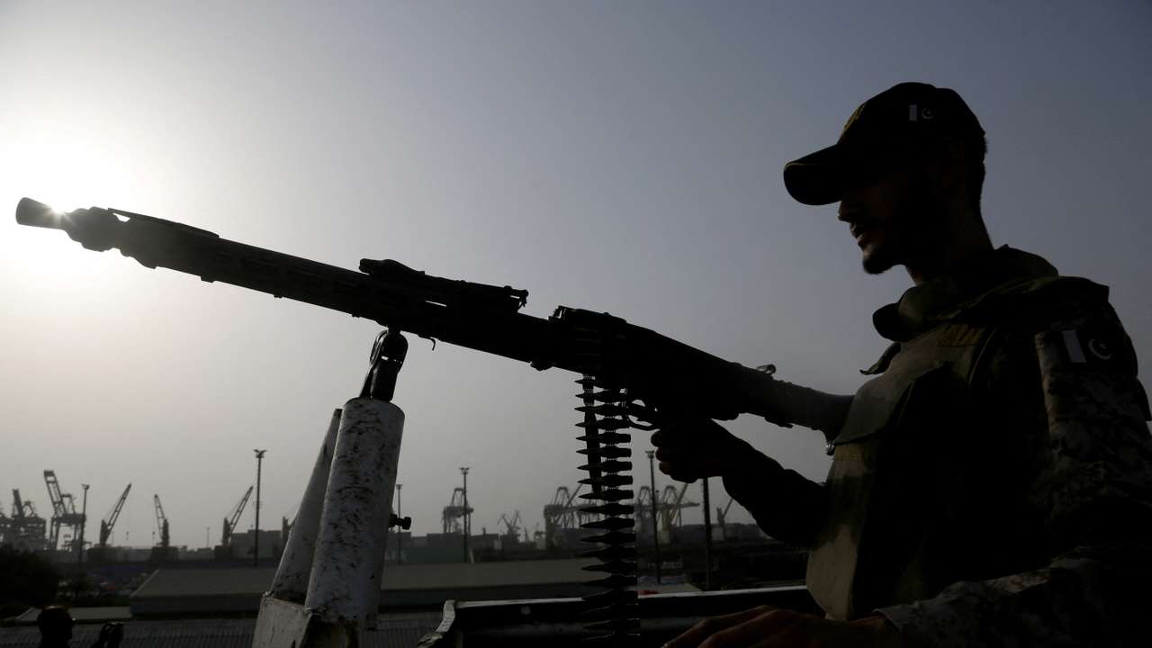 A paramilitary trooper mans a gun atop a vehicle as he keeps guard during a media tour of the Karachi Port