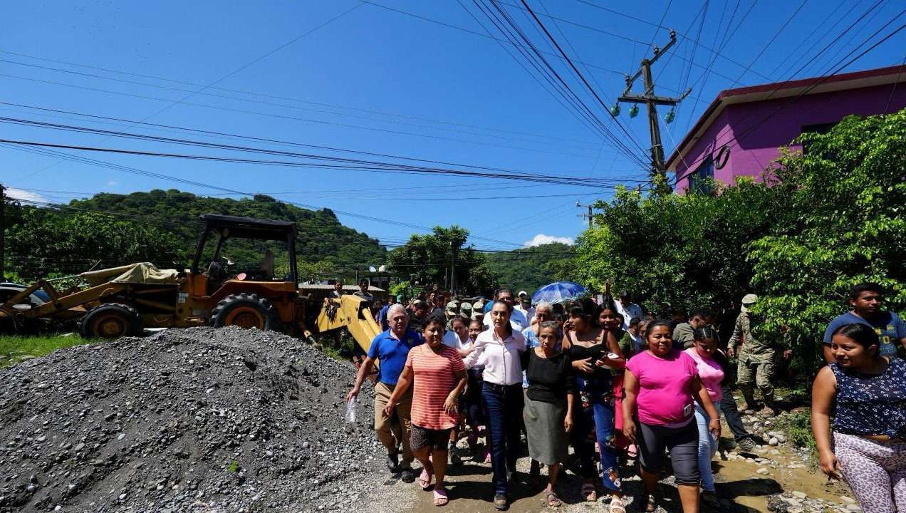 Mexico's President Claudia Sheinbaum walks with residents while visiting areas impacted by torrential rains that left people dead and missing, following downpours that triggered landslides, cut off power in some municipalities and caused rivers to burst their banks, in La Ceiba, Mexico October 12, 2025. Mexico Presidency/Handout via REUTERS ATTENTION EDITORS - THIS IMAGE HAS BEEN SUPPLIED BY A THIRD PARTY NO RESALES. NO ARCHIVES