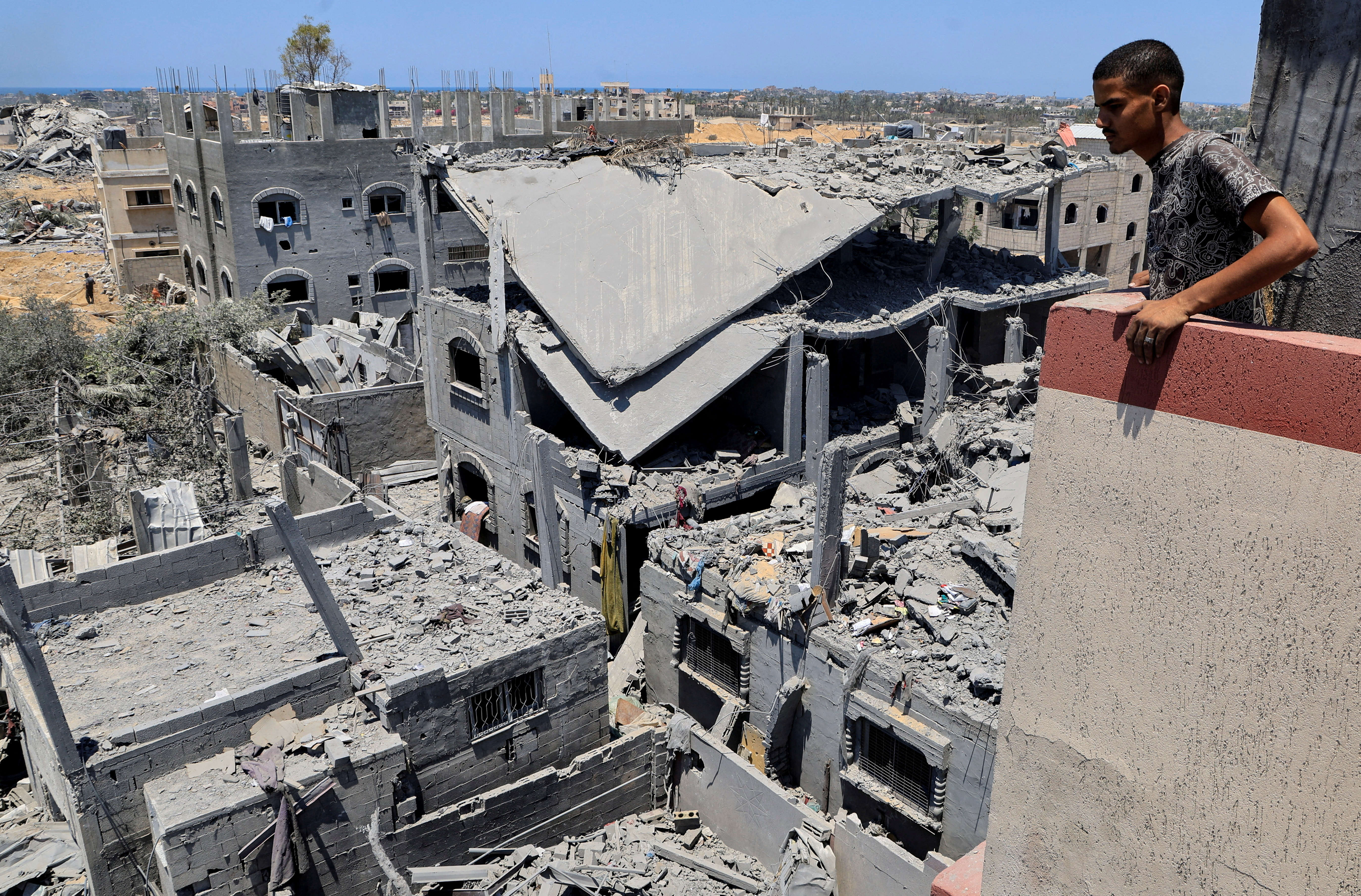 FILE PHOTO: Palestinians inspect houses destroyed during an Israeli military operation, in Deir al-Balah