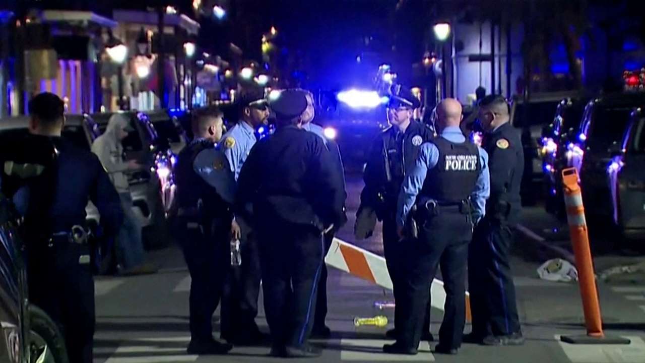Police officers stand at the scene where a truck drove into a large crowd on Bourbon Street in New Orleans