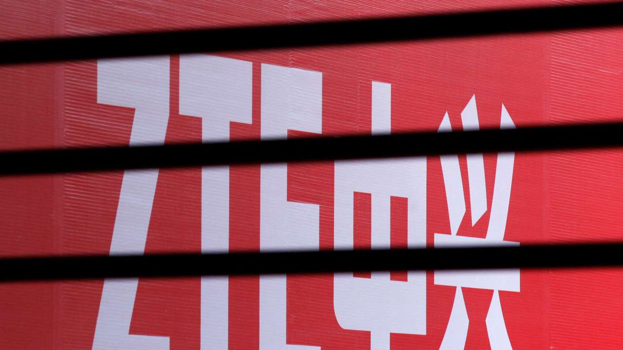 FILE PHOTO: The company logo of ZTE is seen through a wooden fence on a glass door during the company's 15th anniversary celebration in Beijing
