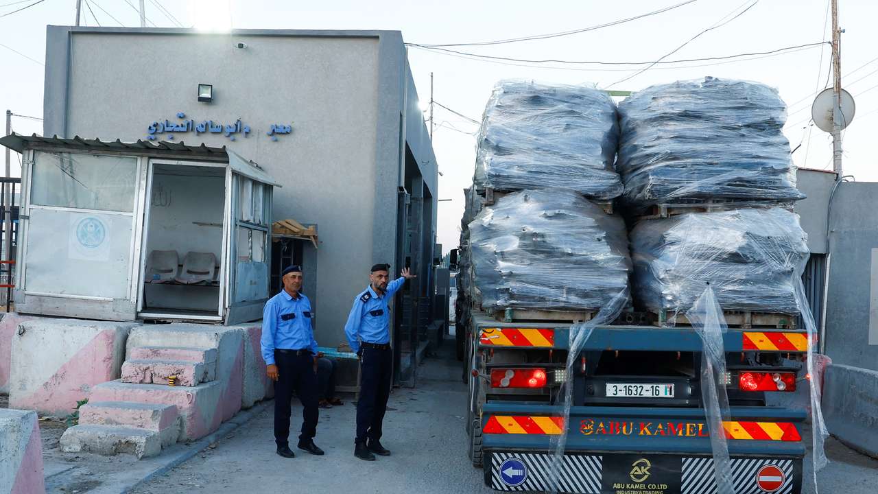 Palestinian police officers walk at the commercial crossing of Kerem Shalom, as Israel ends a ban on exports from Gaza, in Rafah