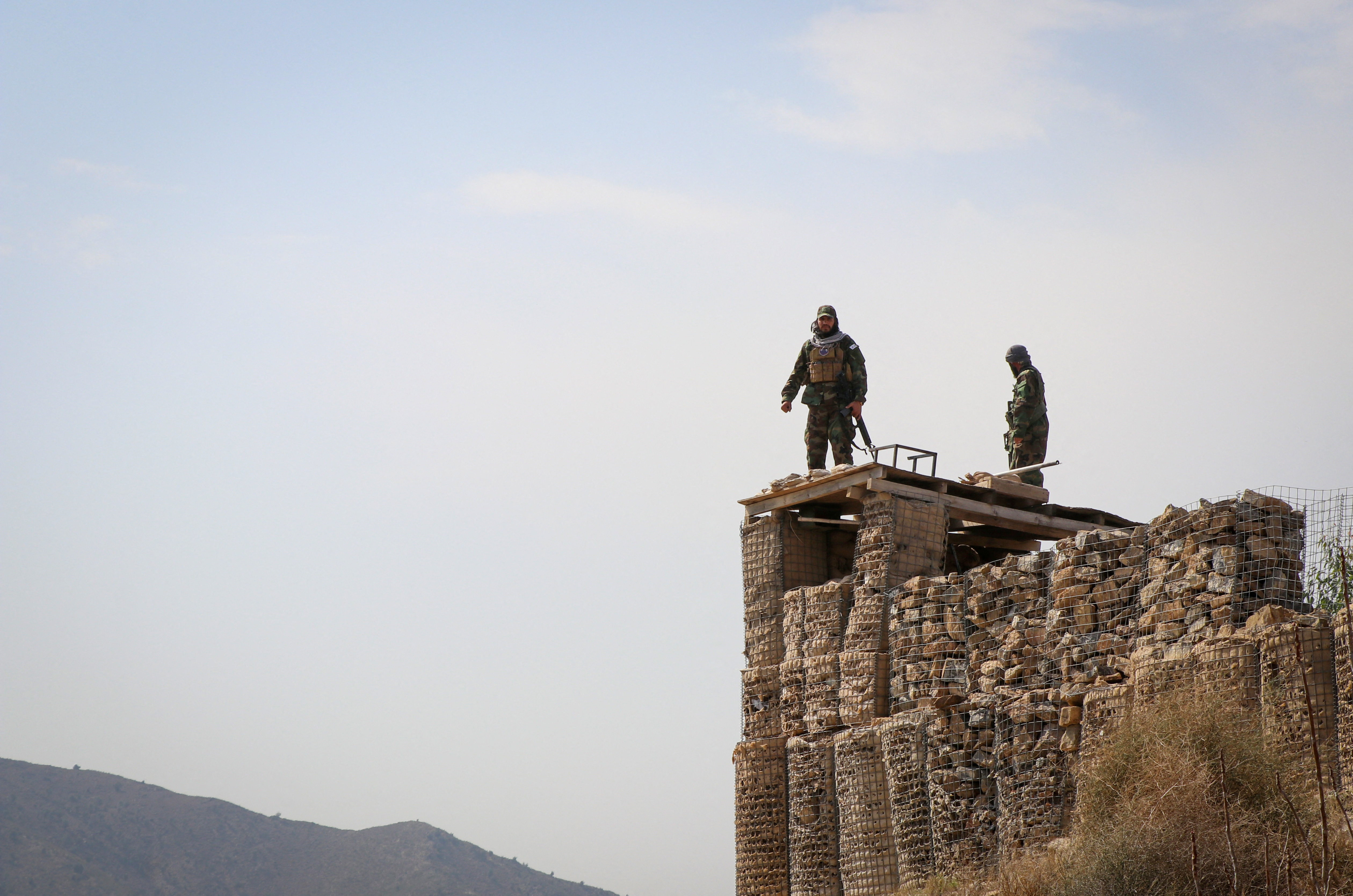 Taliban soldiers stand on top of a their post as they guard near the border, in Khost province
