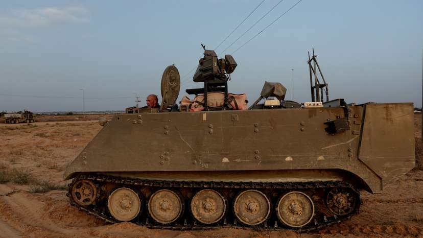 An Israeli solider drives an armored personnel carrier, as military operations continue in the southern Gaza city of Rafah, at an area outside Kerem Shalom, Israel
