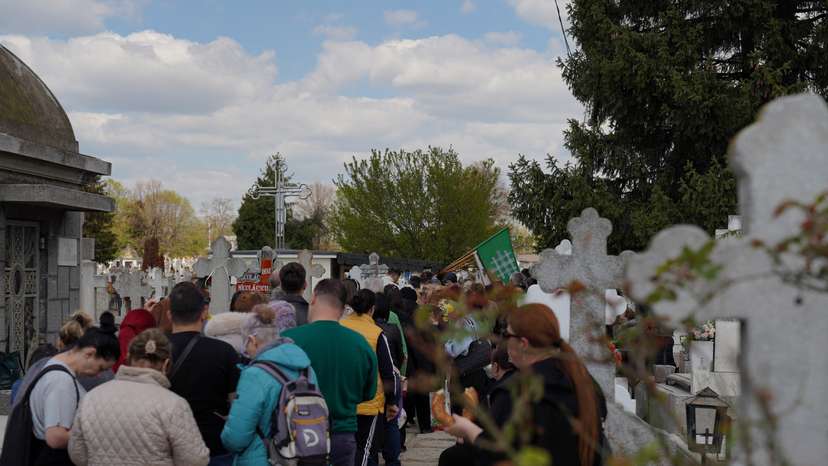 People queue up at a tomb bearing the flag with the insignia of the Iron Guard, in Bucharest