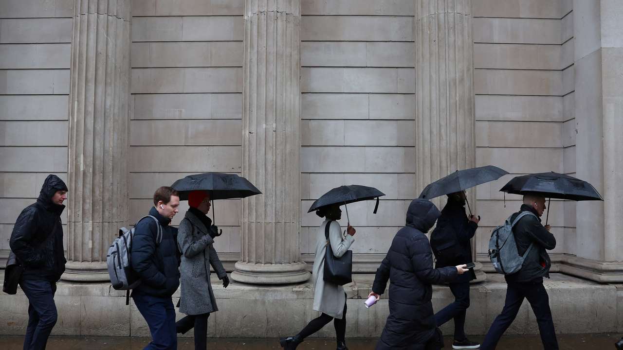 Commuters walk in City of London financial district in London