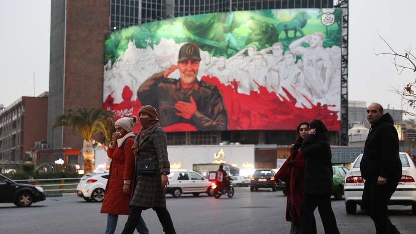 People walk on a street as protests erupt over the collapse of the currency's value in Tehran