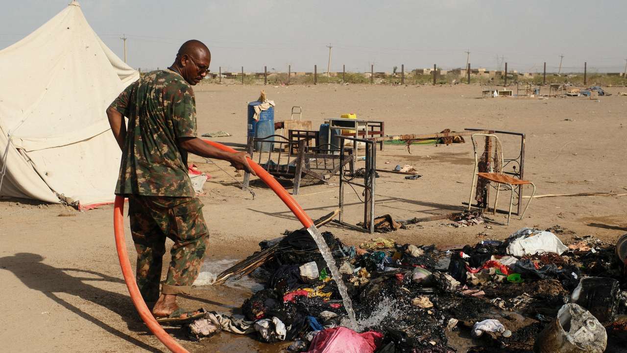 A soldier extinguishes a fire following a drone attack in Ad-Damar