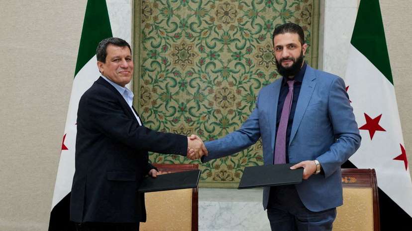 Syria's interim President Ahmed al-Sharaa and Commander of Syrian Kurdish-led forces Mazloum Abdi shake hands in Damascus