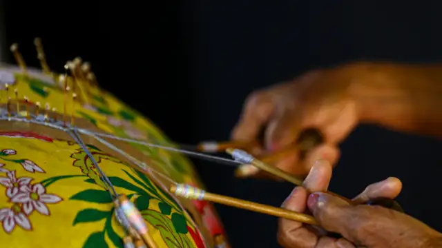 Mãos de mulher artesã.