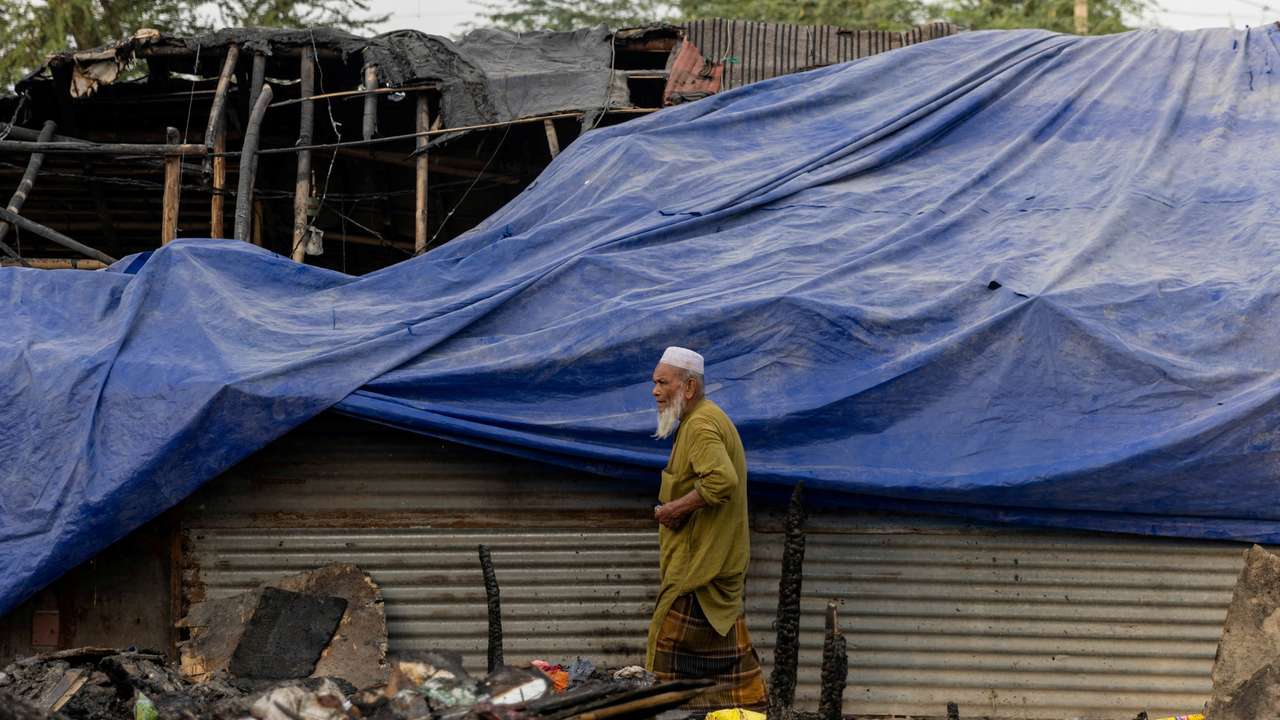 FILE PHOTO: A Rohingya refugee walks past a half-burnt mosque after a fire destroyed a Rohingya refugee camp on Saturday night, in New Delhi
