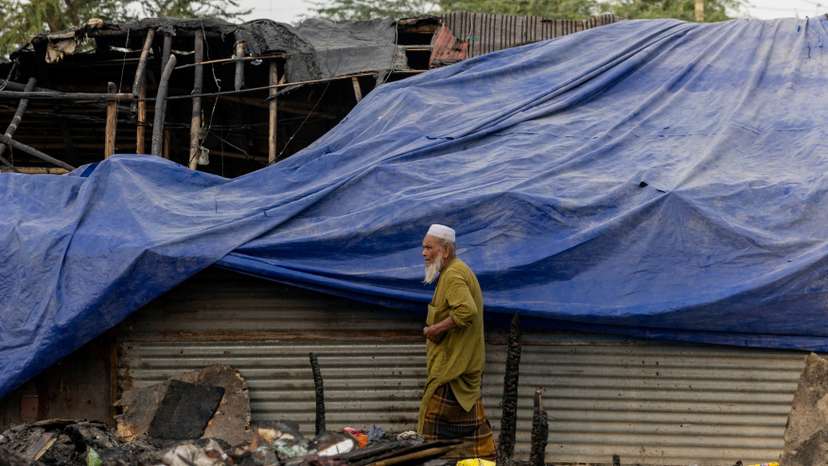 FILE PHOTO: A Rohingya refugee walks past a half-burnt mosque after a fire destroyed a Rohingya refugee camp on Saturday night, in New Delhi
