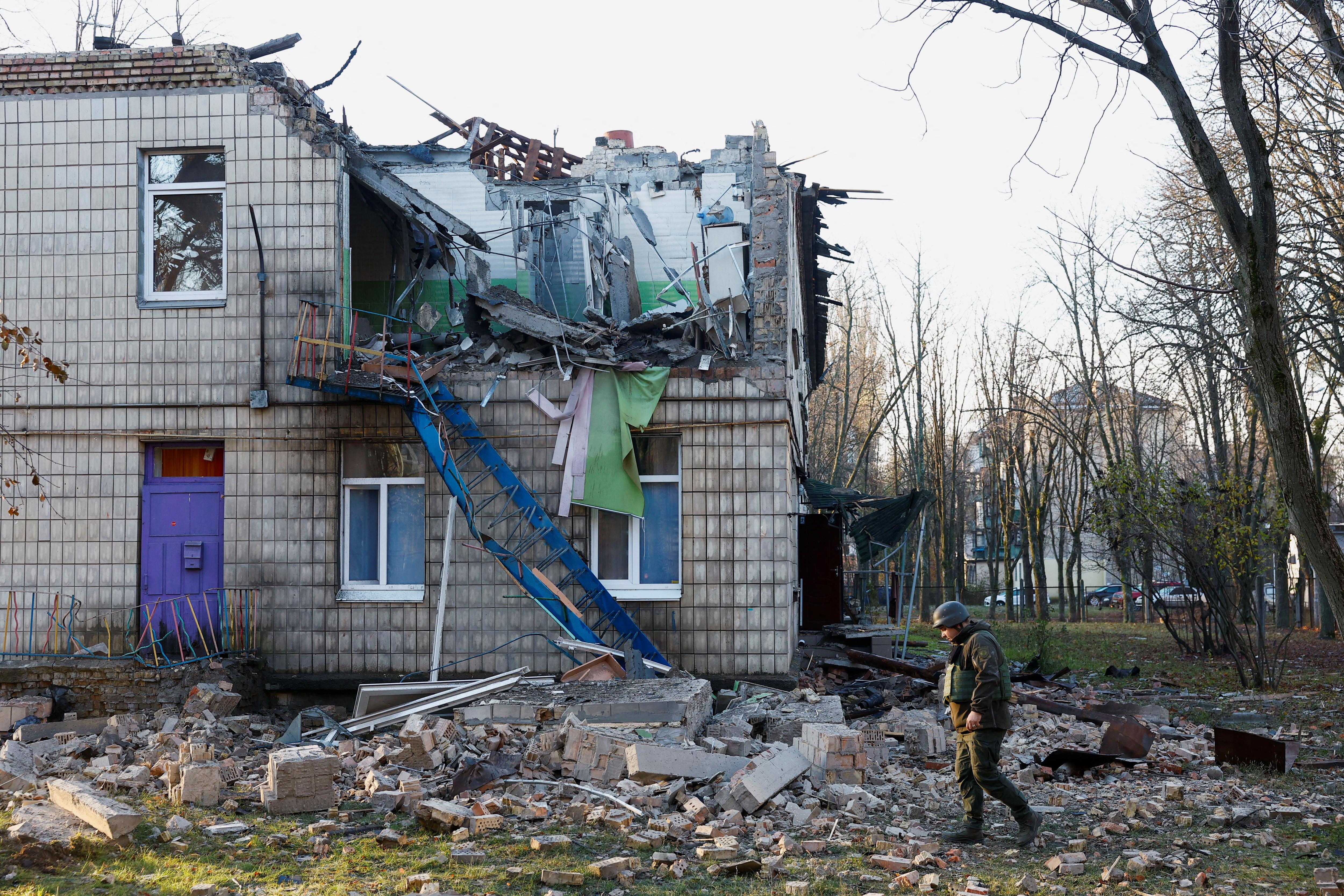 Police officers inspect the compound of a kindergarten damaged during Russian drone strikes, amid Russia’s attack on Ukraine, in Kyiv