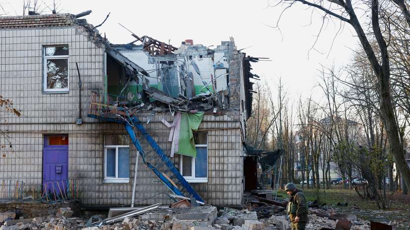 Police officers inspect the compound of a kindergarten damaged during Russian drone strikes, amid Russia’s attack on Ukraine, in Kyiv