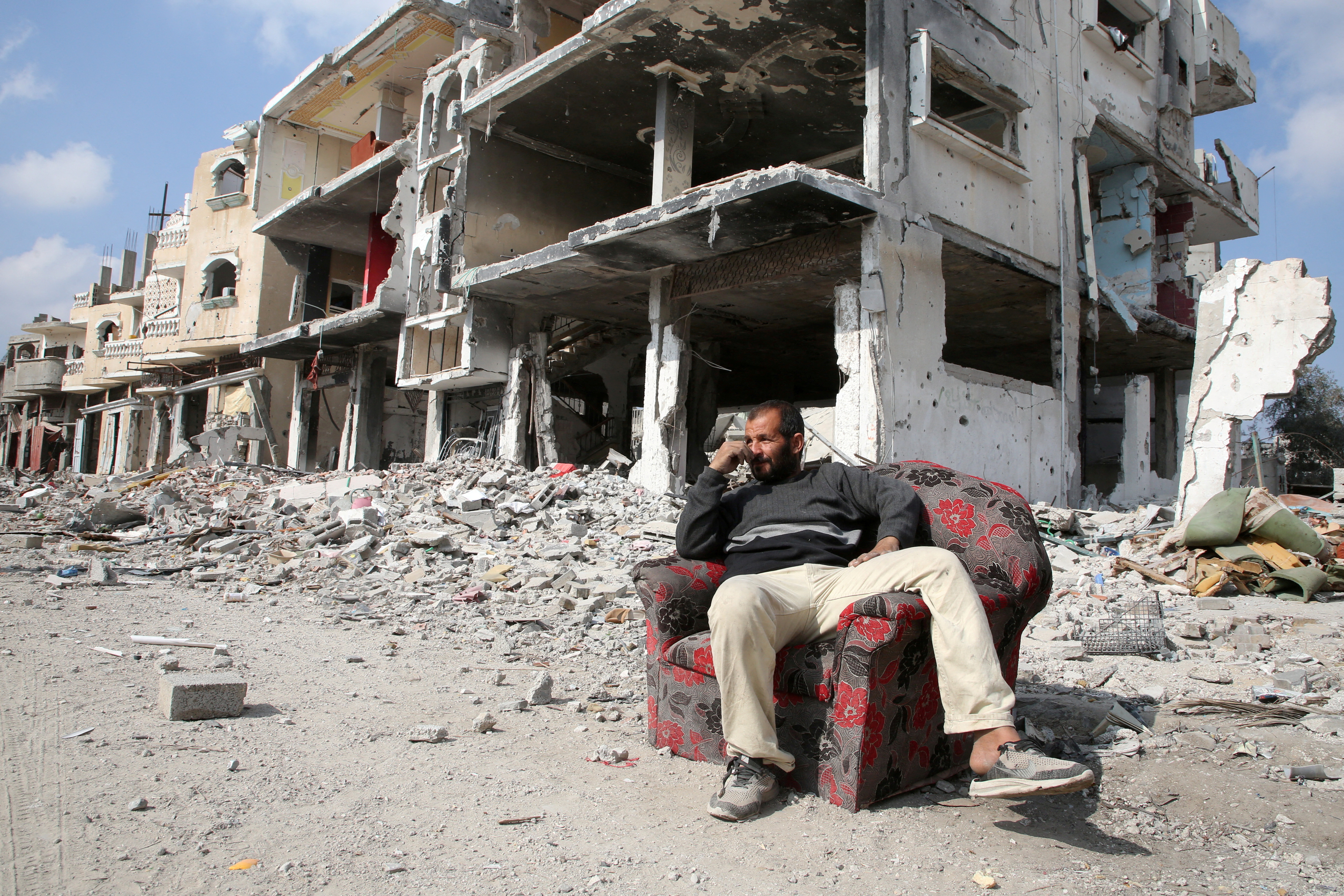 A Palestinian sits among the rubble of buildings destroyed during the Israeli offensive in Rafah