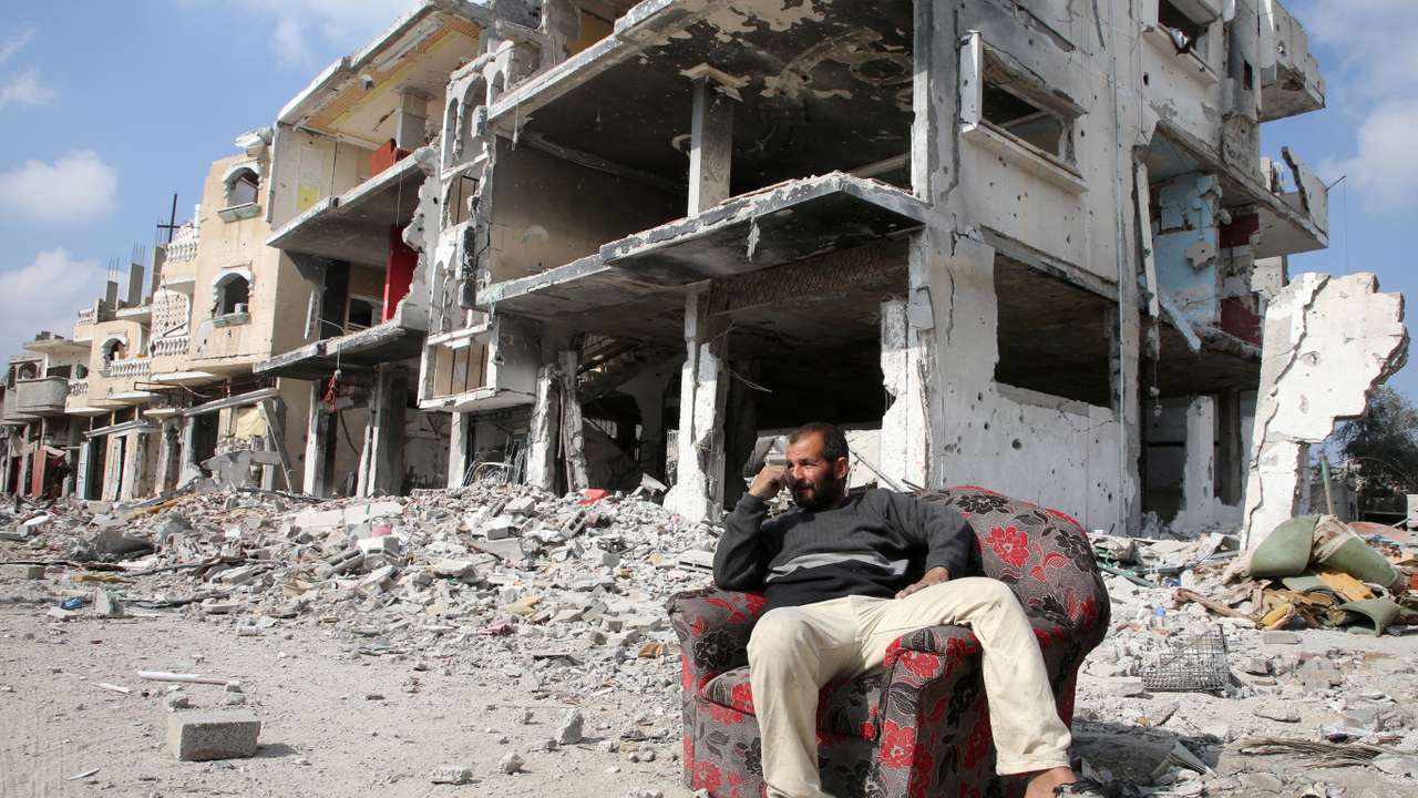 A Palestinian sits among the rubble of buildings destroyed during the Israeli offensive in Rafah