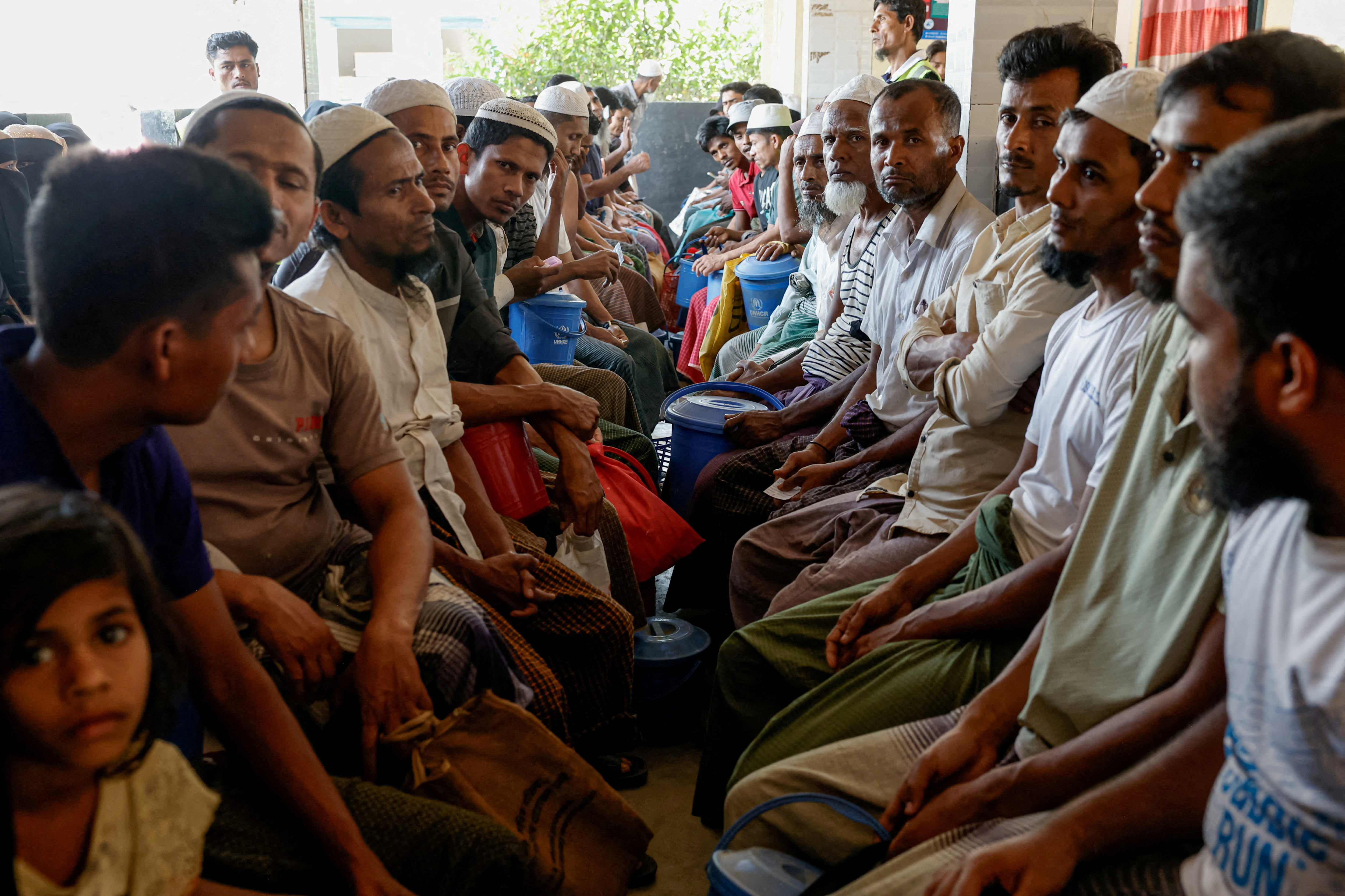 FILE PHOTO: Rohingya refugees wait at the World Food Programme(WFP) distribution center to purchase grocery items, at the refugee camp in Cox's Bazar